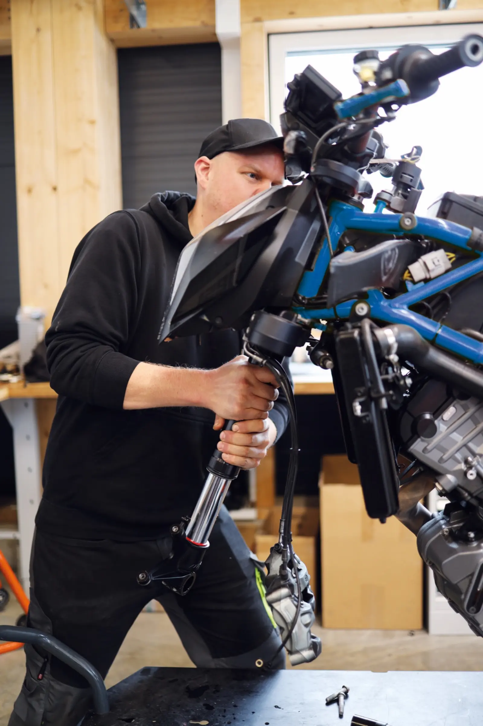 Mechaniker hebt in der Werkstatt einen Motorradrahmen an